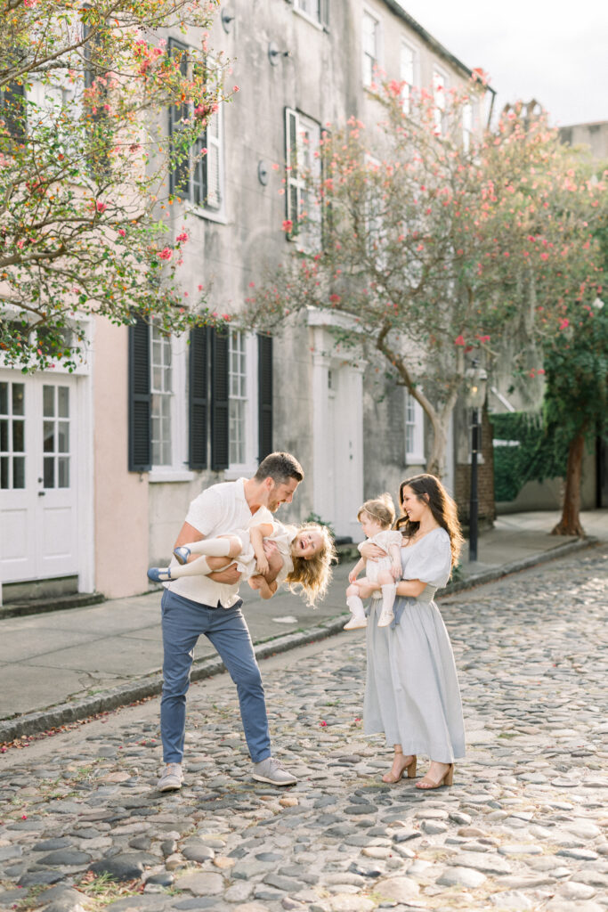 family playing in the streets of downtown Charleston during a family session 