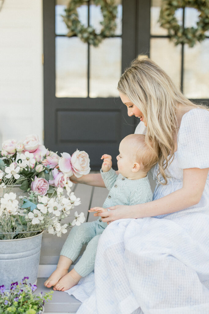 mom and baby boy cuddling on a porch during a mothers day photo session in Tomball at Mason home 