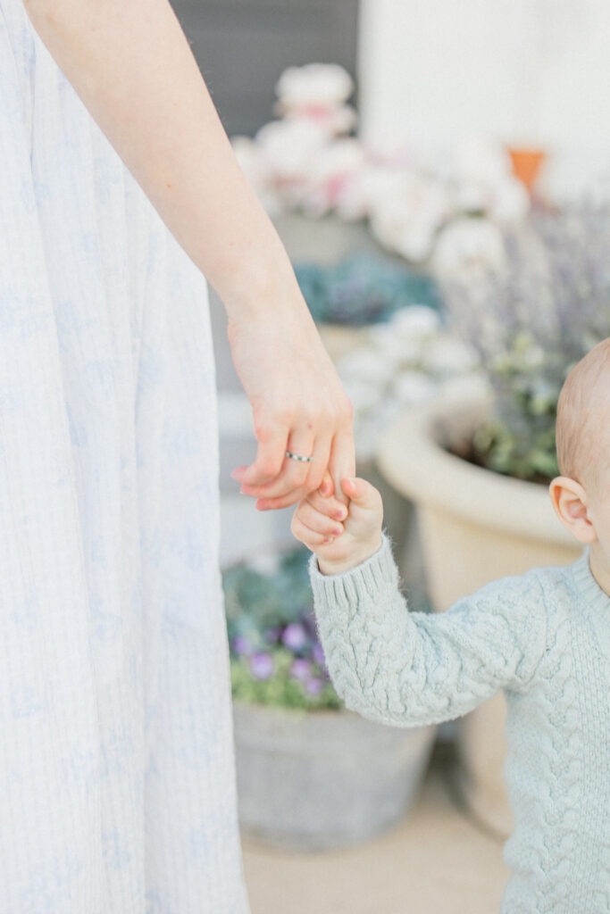 mom and toddler son holding hands in the spring time during a motherhood portrait event in tomball texas