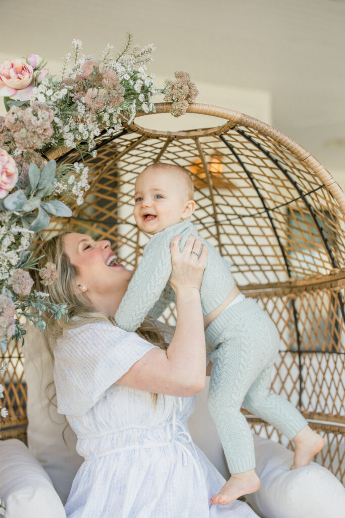 happy mom holding up baby boy during a mothers day photo session in tomball texas at Mason Home 